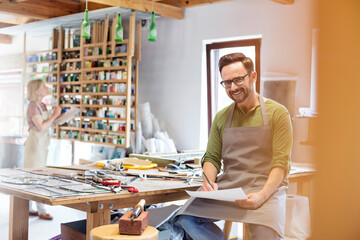 Portrait smiling stained glass artist working in studio