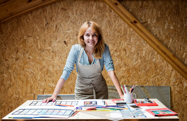 Portrait smiling stained glass artist working in studio