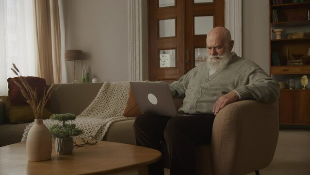Senior Adult Reading Bad News on Laptop, Upset Elderly Man