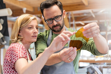 Stained glass artists examining glass pieces in studio