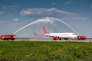Water arch for first visit white passenger jet plane at the airport