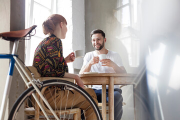 Couple talking and drinking coffee at table