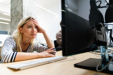 Portrait of a disappointed woman programmer looking stressed out while working on a computer code