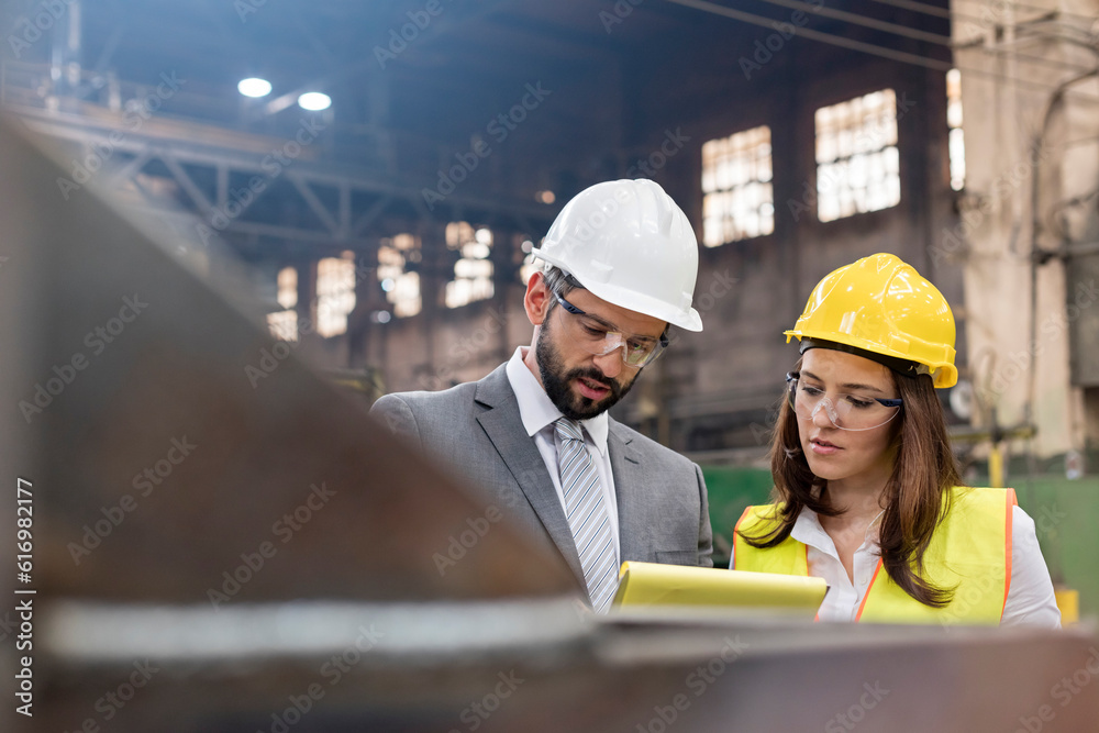 Wall mural Manager and female steel worker meeting in factory