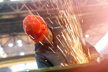 Welder using welding torch with sparks in steel factory - obrazy, fototapety, plakaty