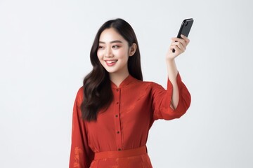 Naklejka premium Portrait of a beautiful young asian woman in cheongsam dress using mobile phone, Generative AI