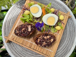 Two tone brown rice onigiri with boiled egg and salad