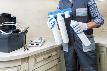 Plumber installing or repairing system of water filtration. Water purification filter install....