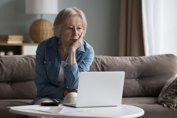 Old stressed woman manage family finances feels desperate due to huge debts, unpaid bills, budget overspend, subpoena received, lack of money to pay monthly utility bills. Financial crisis, bankruptcy