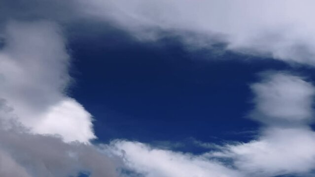 Time lapse footage of white clouds covering the blue sky. Cloudscape.