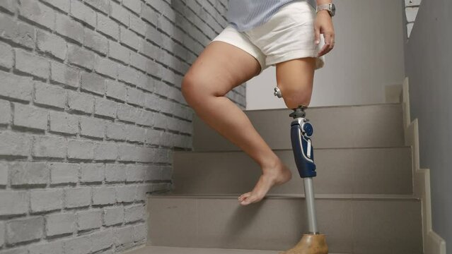 woman wearing prosthetic leg walking down the stairs, equality concept, disability, life difficulties,
