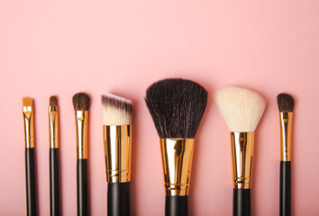 Cosmetic makeup brush on a pink background. Cosmetic product for make-up. Creative and beauty fashion concept. Fashion. Collection of cosmetic makeup brushes, top view, banner.Place for text. MOCAP.