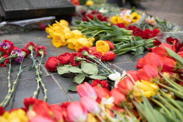 Flowers on war monument. Flowers on grave of soldier. Remembrance ceremony.