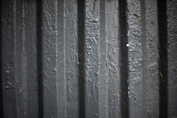 Gray paint on fence. Thick coat of paint. Steel surface.