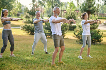 A group of people practicing yoga in a park