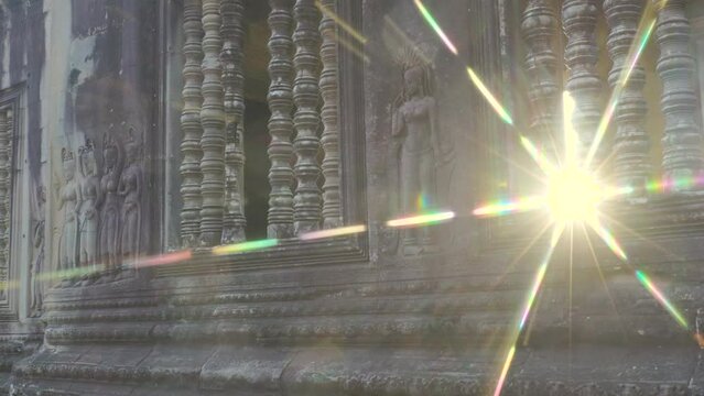 Devata, sometimes referred to as Apsara dancers on the walls of Angkor Wat with star burst sun flair and refractive rainbow light.