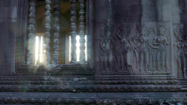Groupe of beautiful Devata, often referred to as Apsara dancers on the walls of Angkor Wat with star burst sun flair and refractive rainbow light.