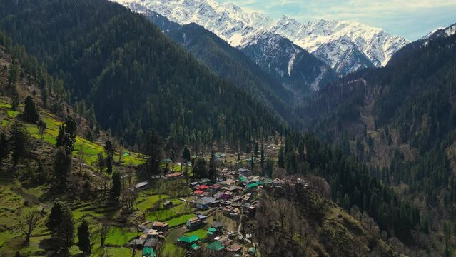 aerial view of Grahan Village - India's Most Beautiful and Hidden village at Himalayas mountains surrounded by snowy mountain - Kasol, India