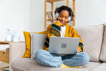 African american girl using laptop at home office looking at screen typing chatting reading writing email. Young woman having virtual meeting online chat video call conference. Work learning from home - obrazy, fototapety, plakaty