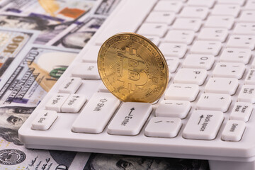 Gold coin with bitcoin cryptocurrency symbol, computer keyboard and 100 american dollar bills