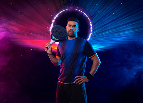 Padel tennis player with racket. Man athlete with paddle racket on court with neon colors. Sport concept. Download a high quality photo for the design of a sports app or betting site.