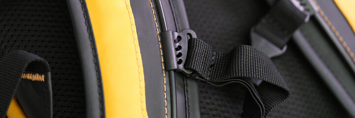Shoulder straps in yellow and black backpack for comfortable carrying on back closeup. Orthopedic backpacks concept