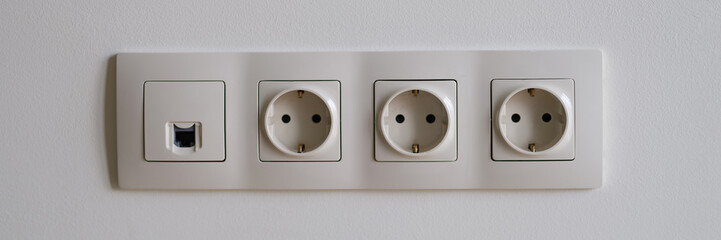 White sockets with wi fi entrance on wall closeup. House wiring installation concept