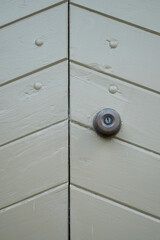A closeup of a heavy wooden door painted grey