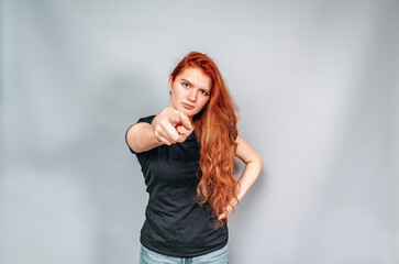 Fototapeta premium Serious young woman pointing finger forward. Management. The woman is the boss.