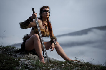 Beautiful female viking woman warrior with sword. Red amazon fantasy