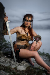 Beautiful female viking woman warrior with sword. Red amazon fantasy