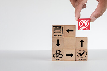 Hand putting red wooden cube with action icon for PDCA cycle idea for businesses, management, and...