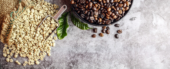 Raw green unroasted coffee beans in brown sacks and roasted coffee beans on wooden background