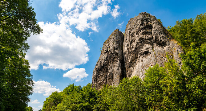 Twin rocks called &ldquo;Pater und Nonne&ldquo; (father and nun) near Iserlohn-Letmathe Sauerland Germany in the lenne valley, natural site. Panoramic view on a sunny summer day with blue sky and green foliage.