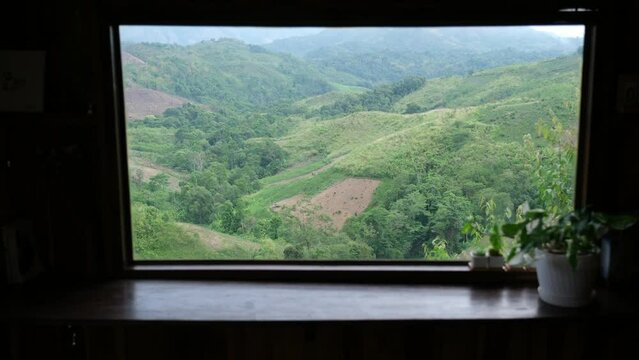 Landscape image of a beautiful greenery mountains view through the window