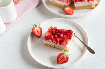 Strawberry cake with whipped cream on short crust pastry on a plate
