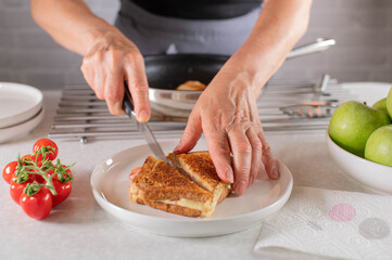 Cutting a fresh ham and cheese sandwich in half
