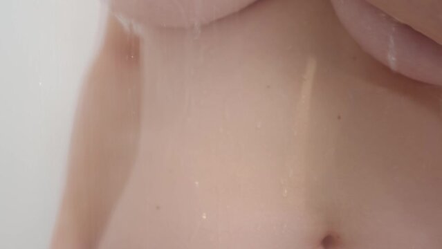 Water flows off a woman's breasts showering 