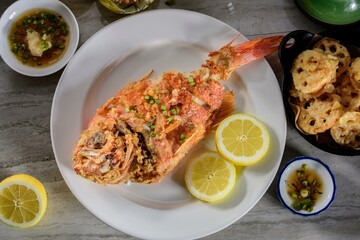 Deliciously Crispy: Top Close-Up of Deep Fried Red Snapper Fish lemon on a plate in 4K