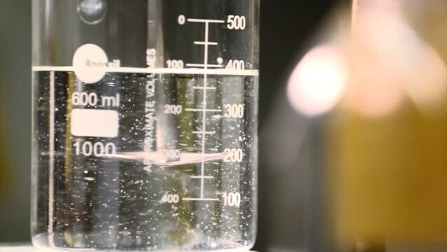 The scientist dropping the chemical solution in beaker in the laboratory experiment. Chemical and Oil concept