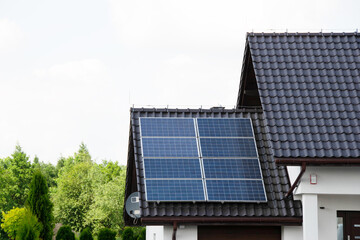 Naklejka premium Installing a Solar Cell on a Roof. Solar panels on roof. Historic farm house with modern solar panels on roof and wall. High quality photo