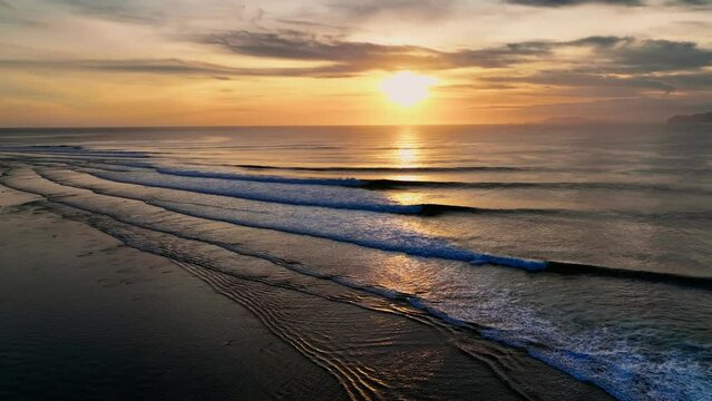 Drone clip showing surfers paddling through perfect point break at G-Land, Java, Indonesia at sunset