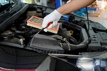 Car mechanic using a screwdriver to tighten a screw car air filter