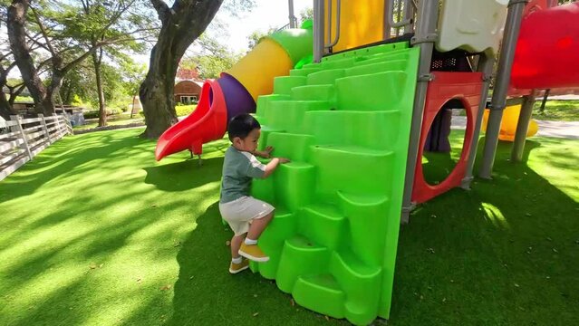 Playful Asian Toddler Boy Enjoying an Active Playground Adventure