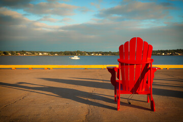 Red Adirondack chairs in front of the ocean in Prince Edward island - 617016585
