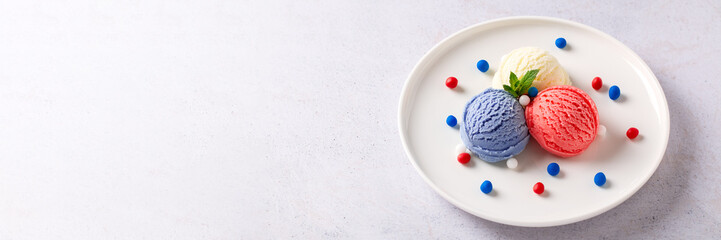 Patriotic colors ice cream scoops on white plate, Red, white and blue ice cream closeup, top view,...