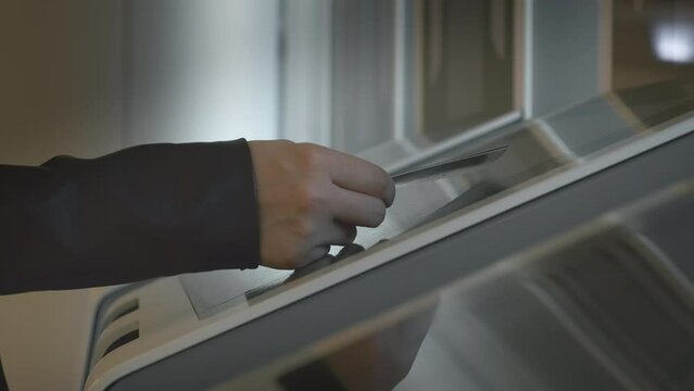 Woman puts boarding pass with document on automatic reader at jetway door. Traveller verifies validity of ticket to access airliner board closeup