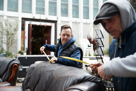 Male workers measuring leather sofa