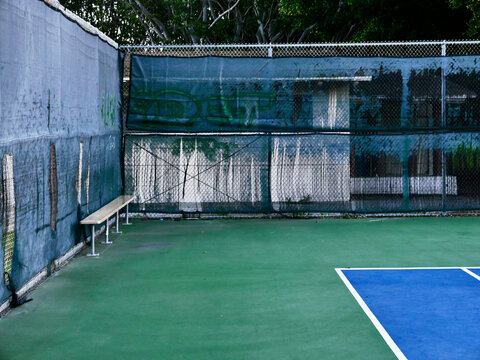 Empty tennis court with bench