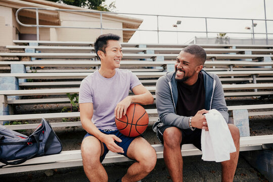 Two friends talking on bleachers�after basketball training�